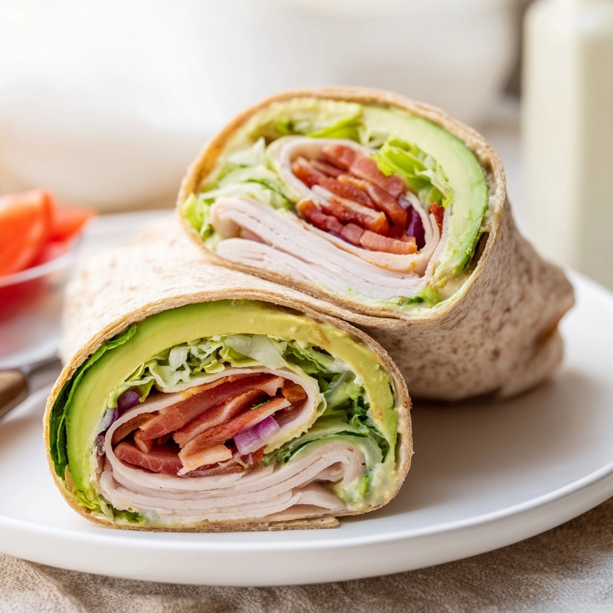 Creamy Avocado and Turkey BLT Wraps, sliced open displaying colorful layers, ready to eat.