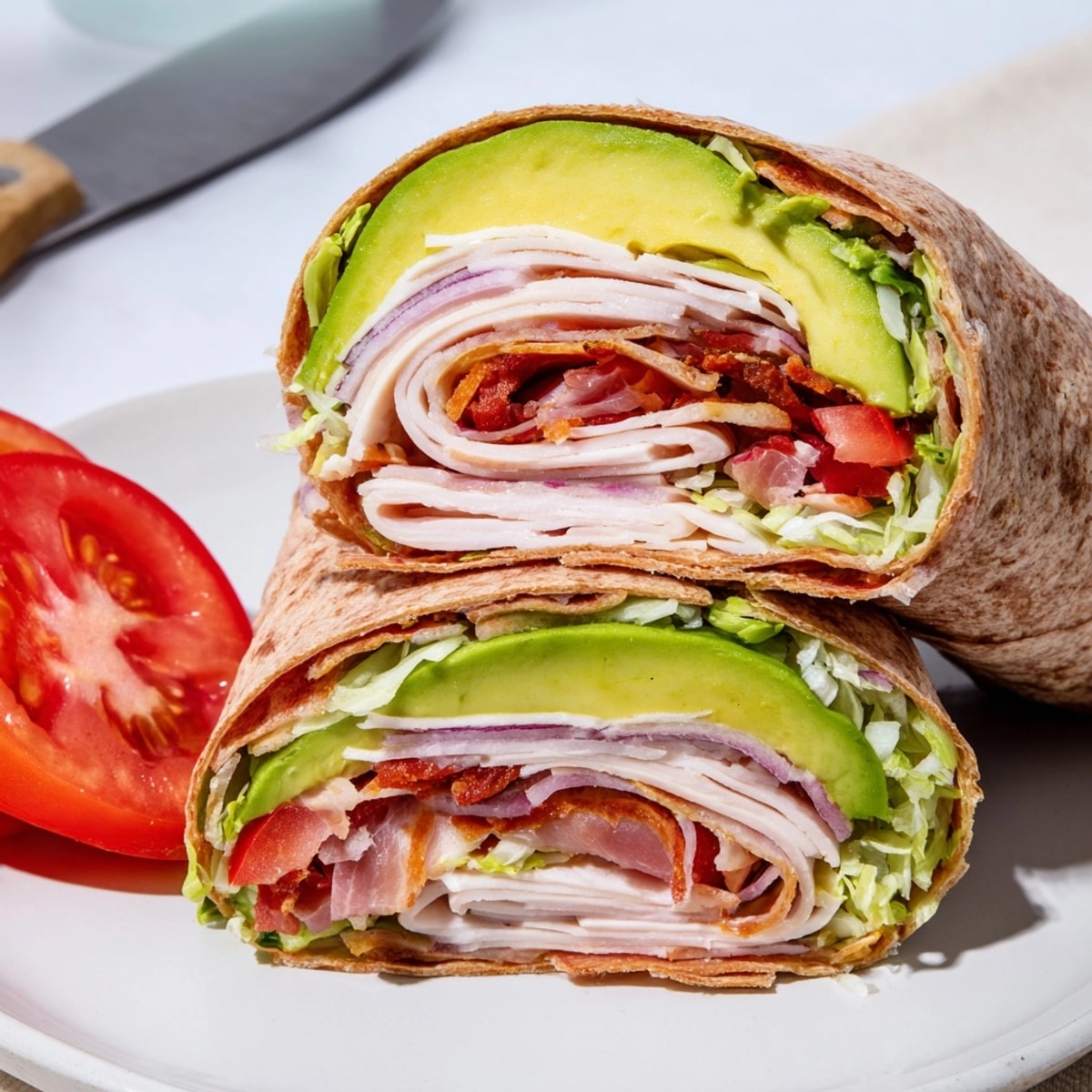 Making fresh Avocado and Turkey BLT Wraps, showing hands layering ingredients onto a tortilla.