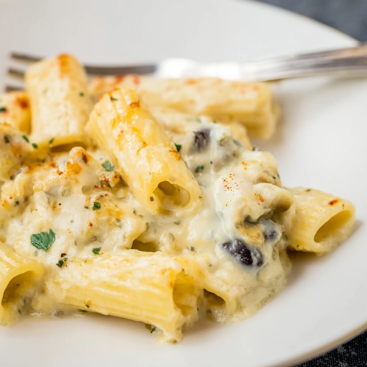 Delicious layers of Alfredo Black Bean Pasta Bake topped with golden, gooey cheese.