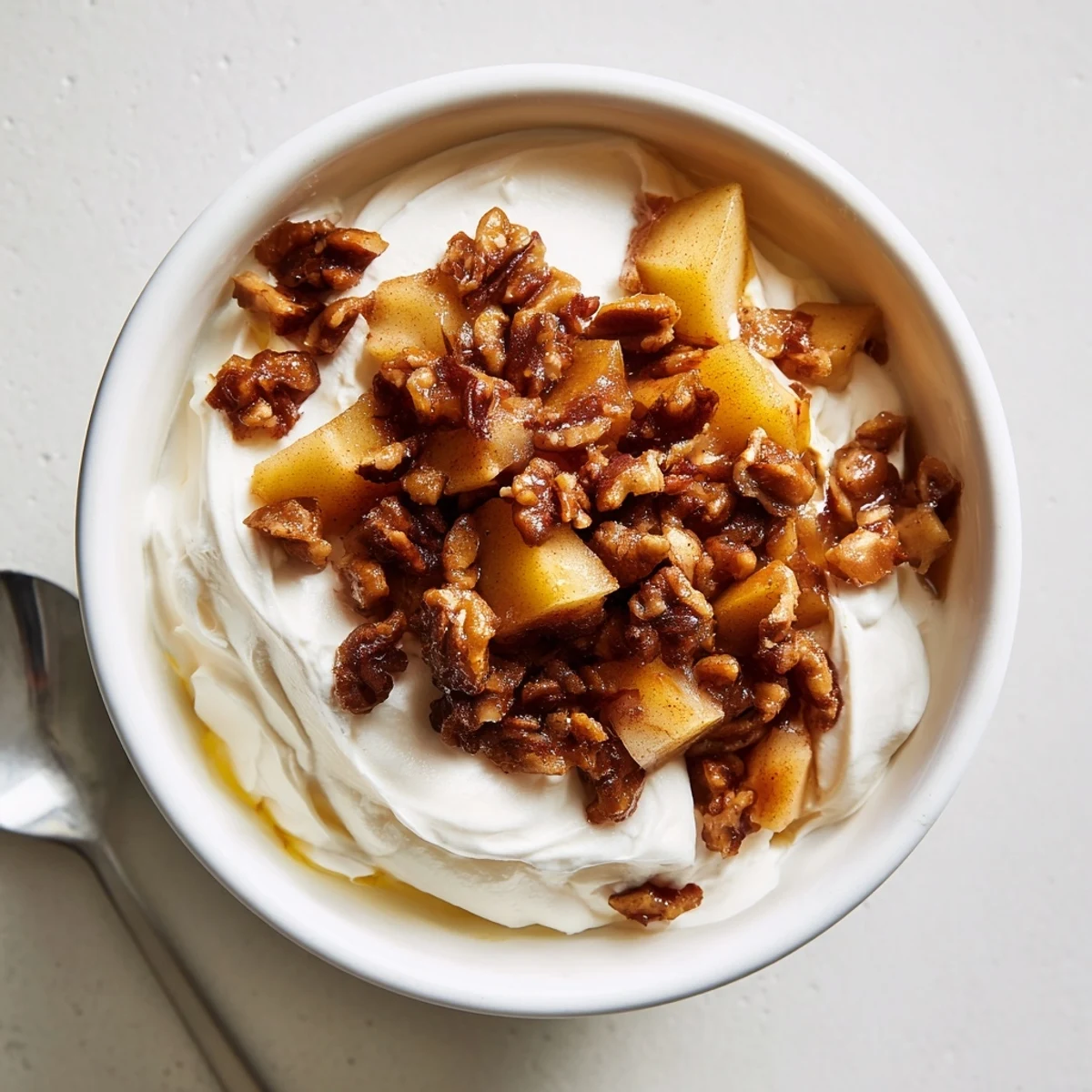 Creamy Spiced Apple Praline Whip Dip topped with crunchy pecan clusters and syrupy apples.