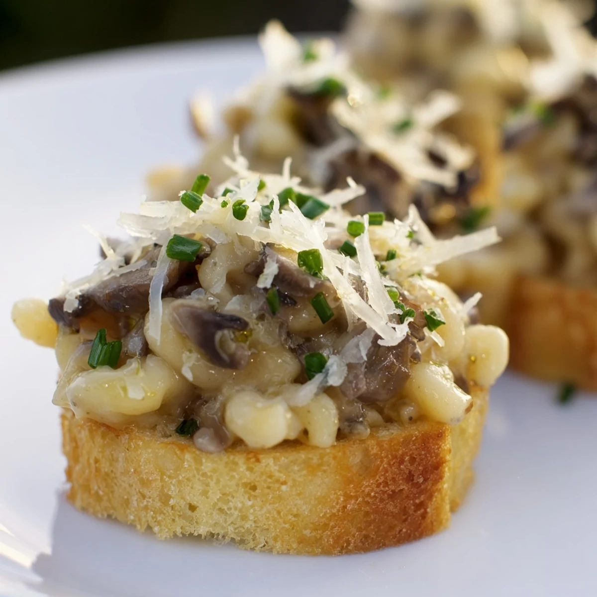 Luxurious truffled mushroom mac crostini topped with creamy cheese and fresh chives.