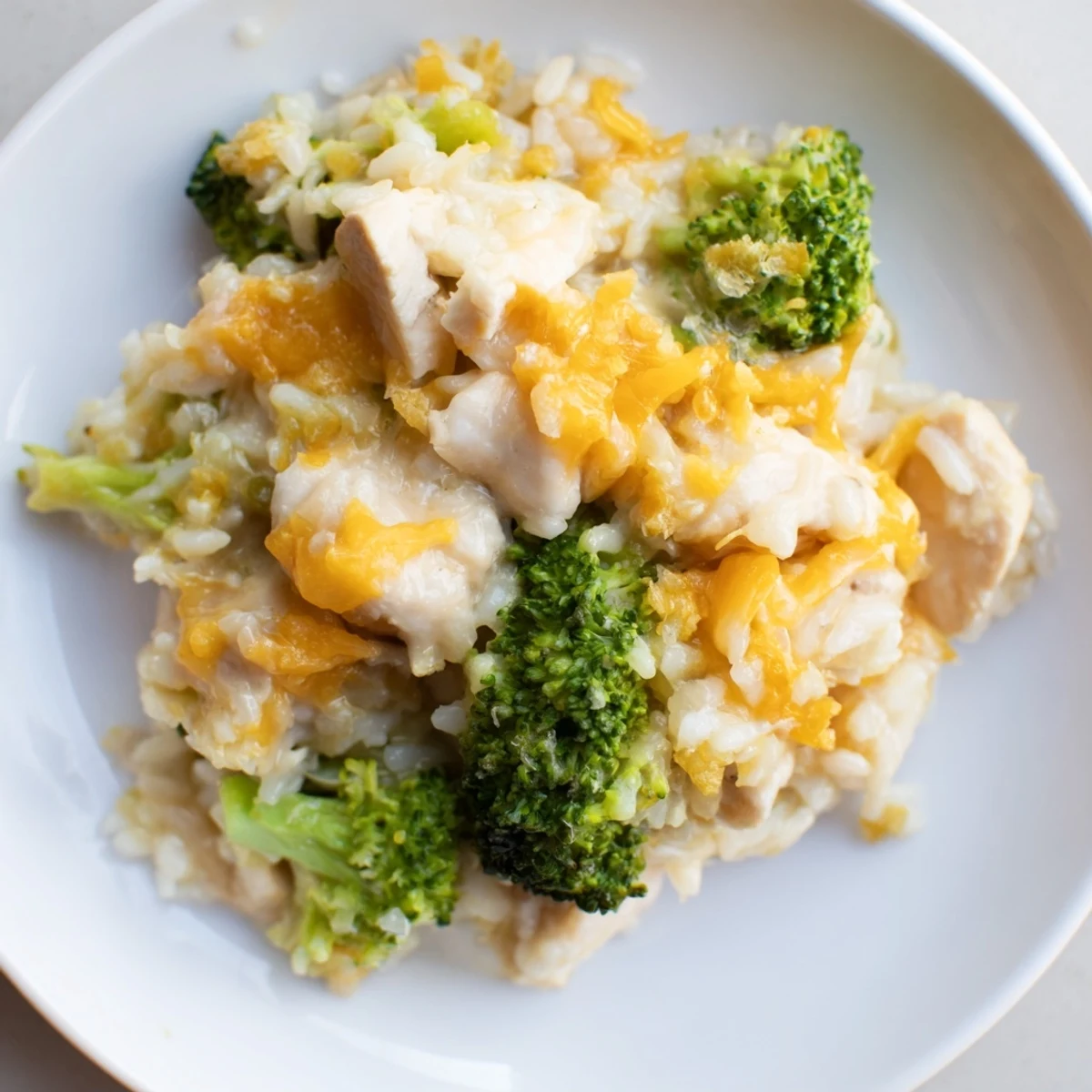 A close-up of a creamy Chicken & Broccoli Rice Casserole, rich with vegetables and tender chicken pieces.