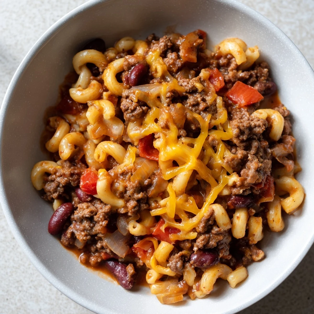 A bubbling skillet of Cheeseburger Chili Mac simmering, the aroma of beef and spices filling the kitchen.