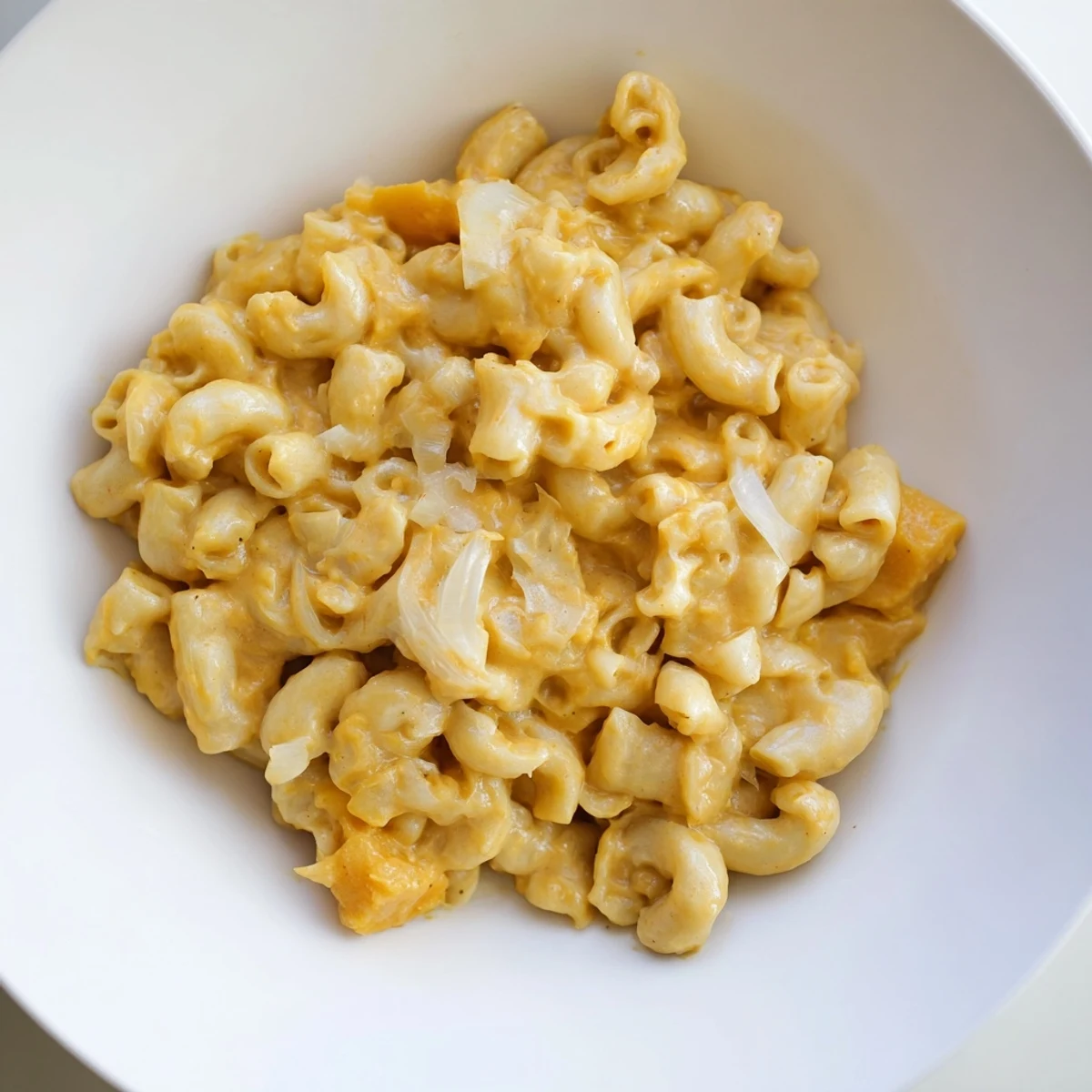 A comforting close-up shot of the rich, orange butternut squash mac & cheese, steaming hot.