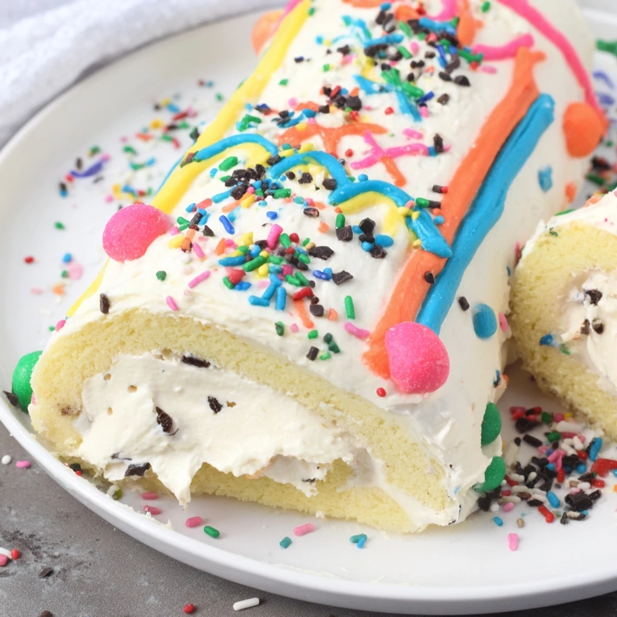 Festive Ugly Sweater Cake Roll slices with colorful frosting, sprinkles, and candies, ready to serve.