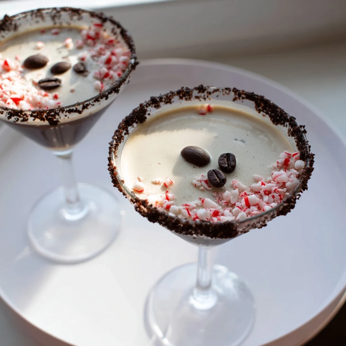 Garnished espresso beans crown a refreshing Peppermint Espresso Martini in a chilled glass.
