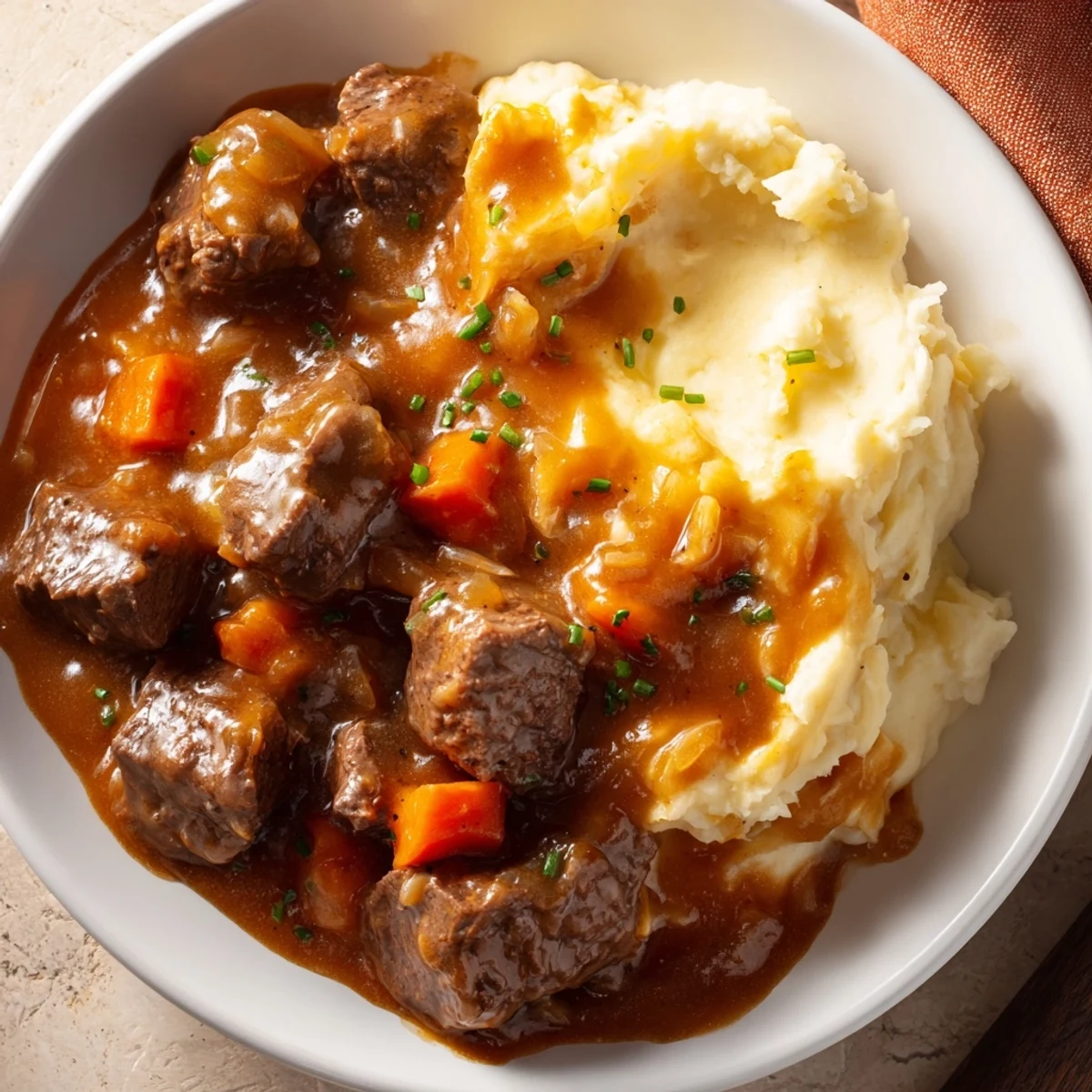 Fall Apple Cider Stew Mash: Tender beef stew over creamy mashed potatoes, sprinkled with fresh chives.