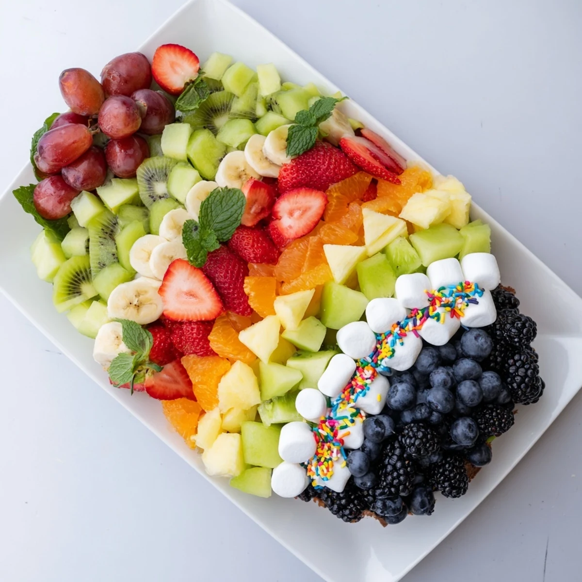 A beautiful, refreshing fruit board shaped like a Happy Birthday Cake slice, perfect for a party.