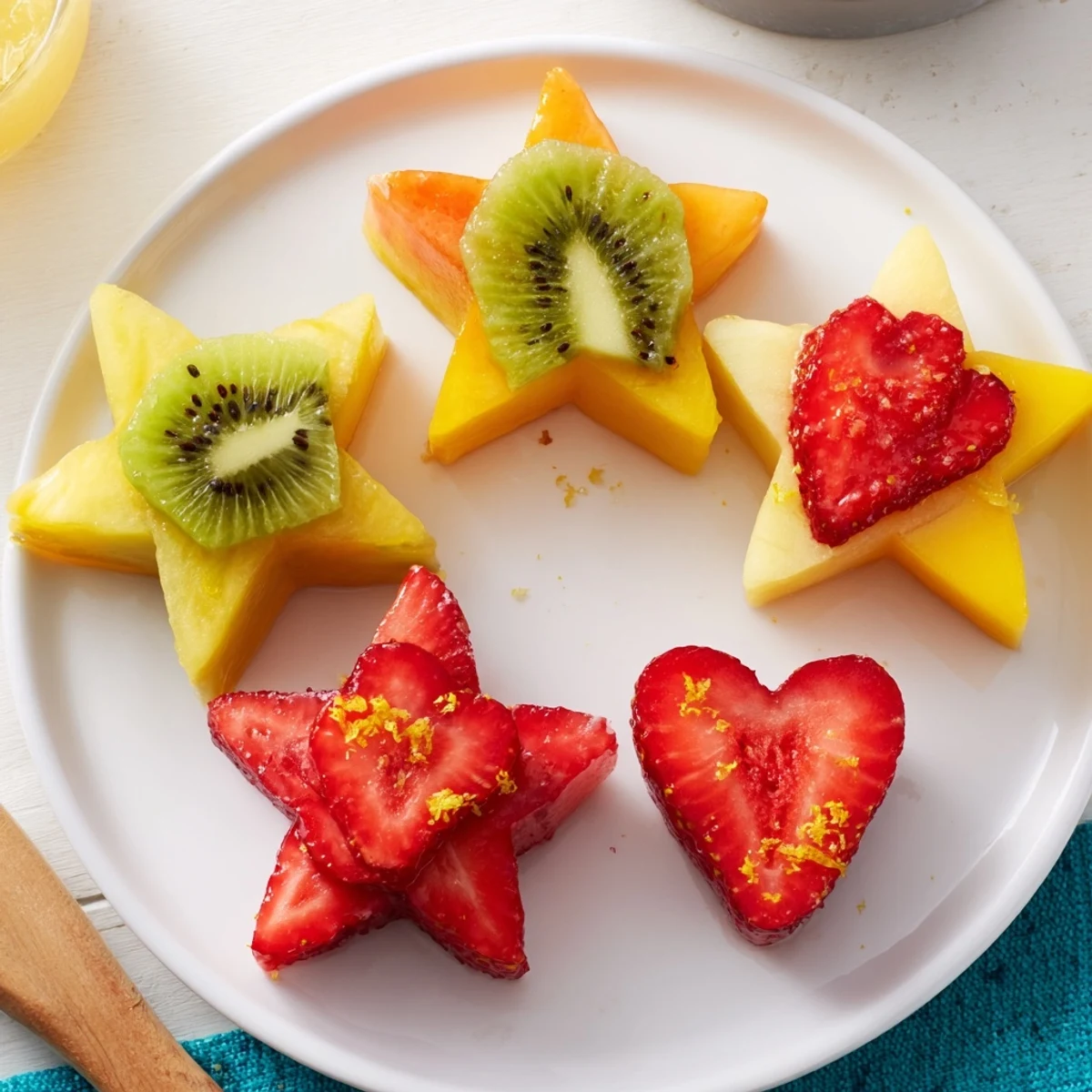 Edible stars and hearts, cut from fruit, add a vibrant touch to Midnight Kiss cocktail garnishes.