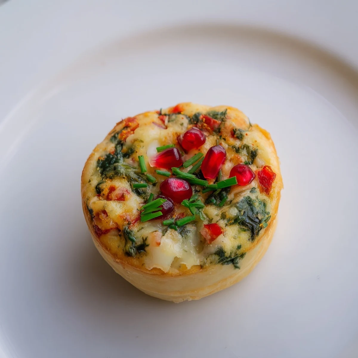 Appetizing mini quiche Christmas tree, with colorful diced pepper "ornaments" topping golden pastry bites.