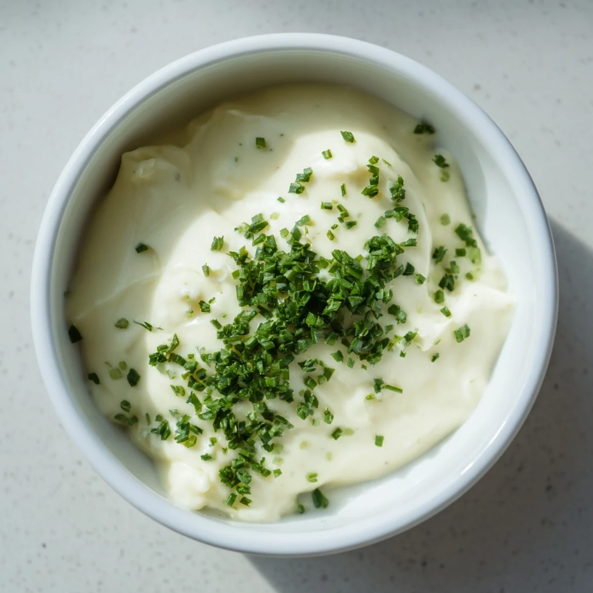 A close-up of creamy and flavorful Veggie Ranch Dip, speckled with chives, ideal for easy entertaining.