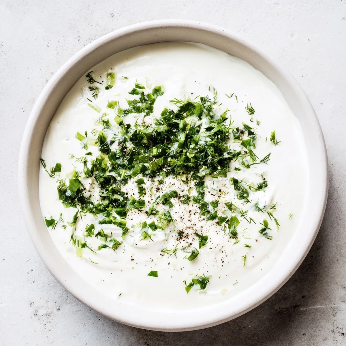 Creamy Greek yogurt ranch dip, studded with green herbs, perfect for dipping fresh veggie sticks.