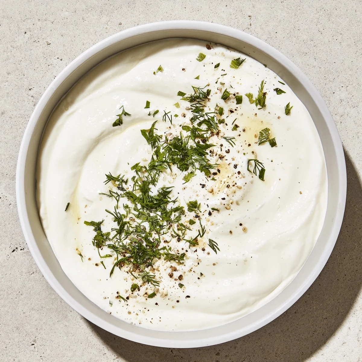 A swirl of vibrant, creamy Greek yogurt ranch dip, ideal for serving with colorful crudités at a party.