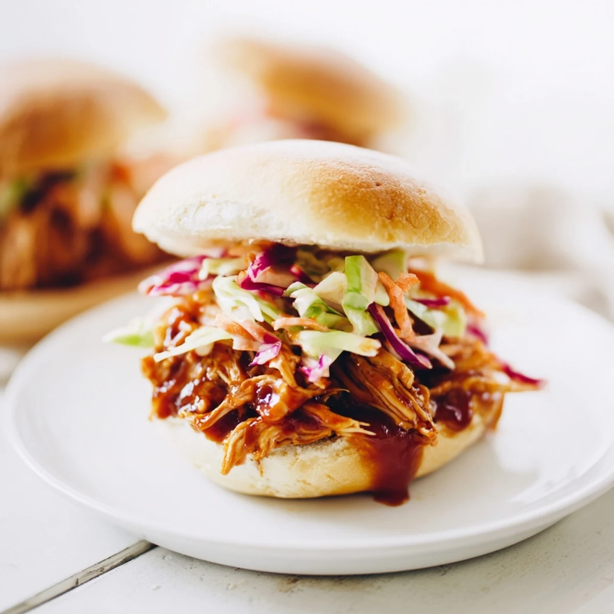 A close-up of delicious BBQ Chicken Sliders, showcasing tender chicken nestled in mini buns.