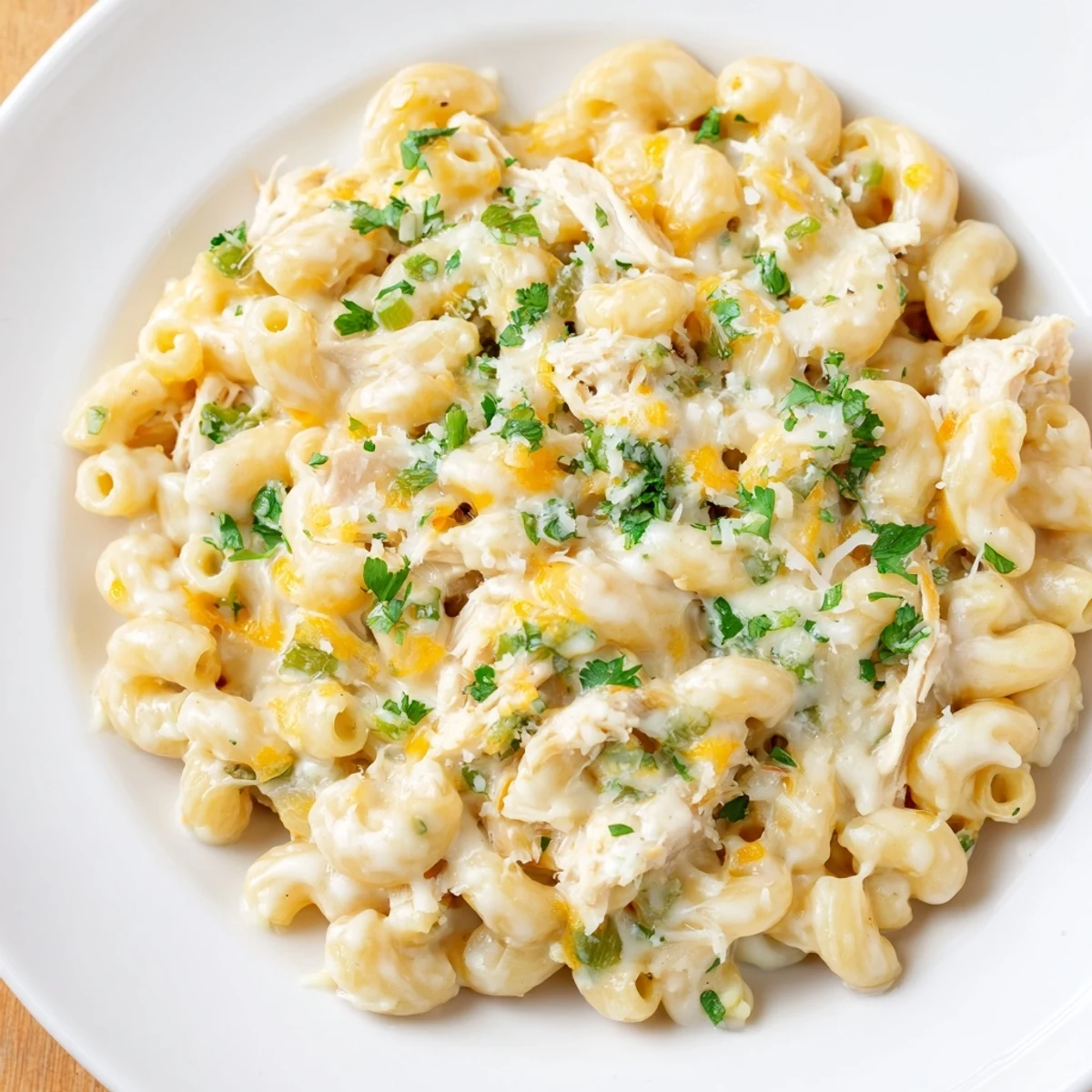 Creamy Green Chili Chicken Mac, topped with melted cheese and fresh cilantro, looks delicious.
