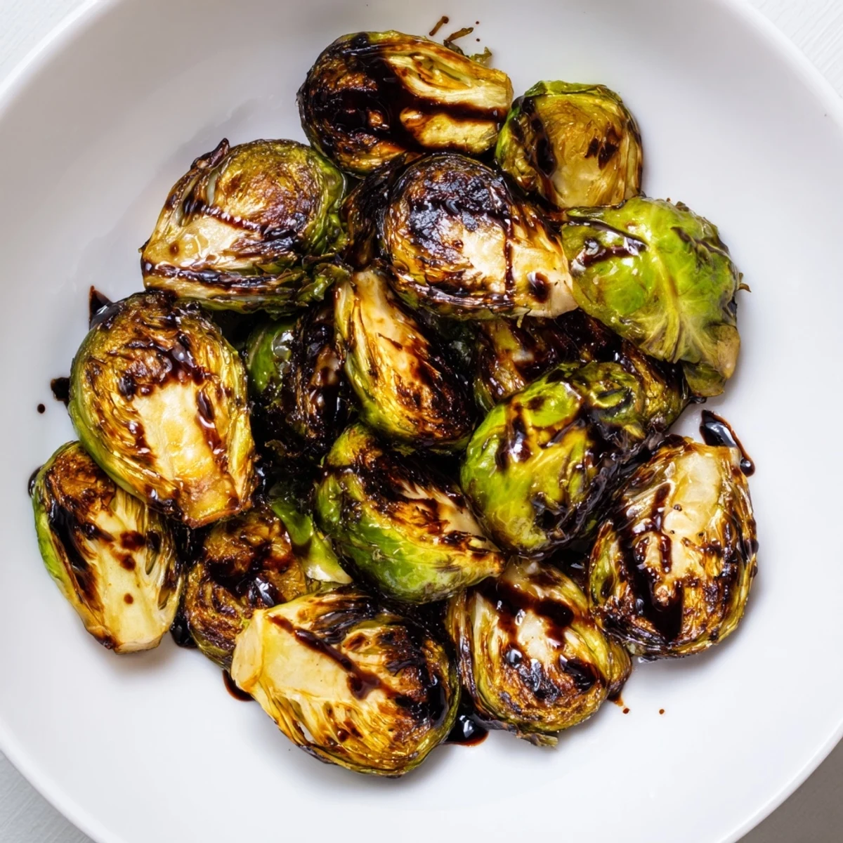 Close-up of caramelized Brussels sprouts with balsamic reduction, highlighting crispy edges for a flavorful accompaniment.
