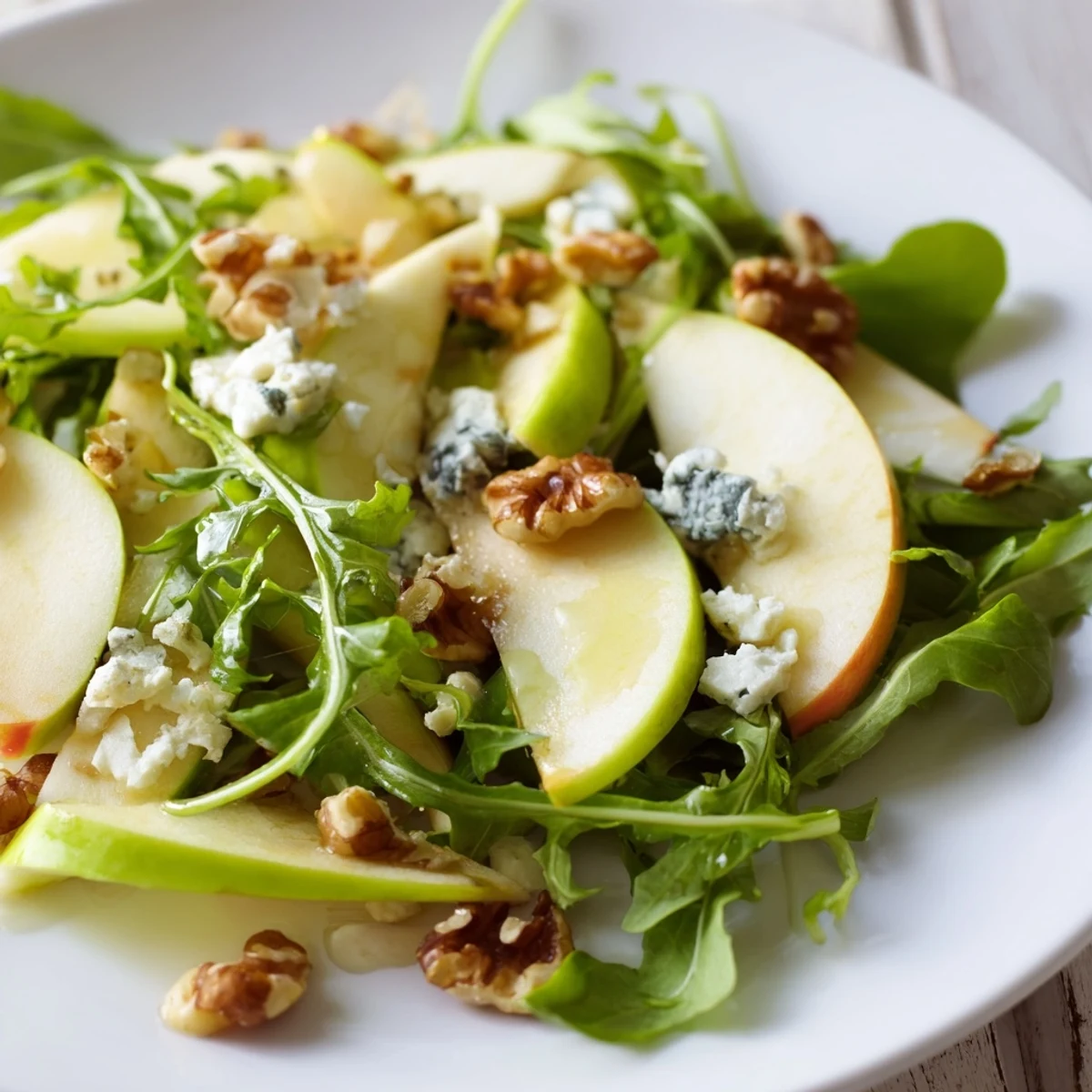 A close-up of crisp Apple and Walnut Salad with crumbled cheese, celery, and vinaigrette, ready to serve as an appetizer.  