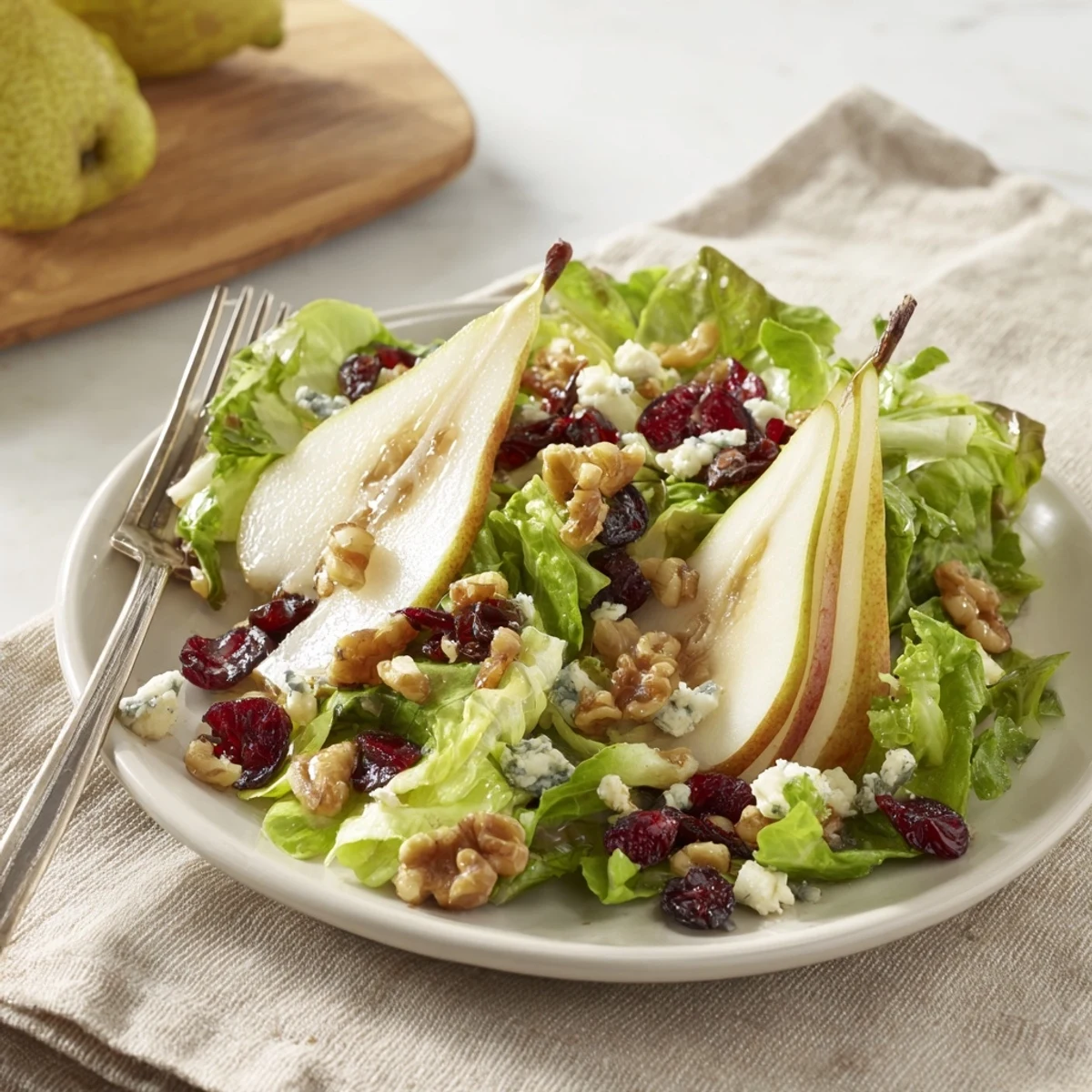 Vibrant vegetarian salad with juicy pears, creamy Gorgonzola, crisp greens, walnuts, and a glistening honey-balsamic dressing, ready to enjoy.