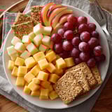 A plate of fruit and cheese.