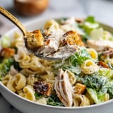 A bowl of chicken Caesar pasta salad.