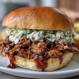 Tender, smoky pork piled high on soft slider buns, topped with crunchy, tangy coleslaw for a crowd-pleasing bite.  