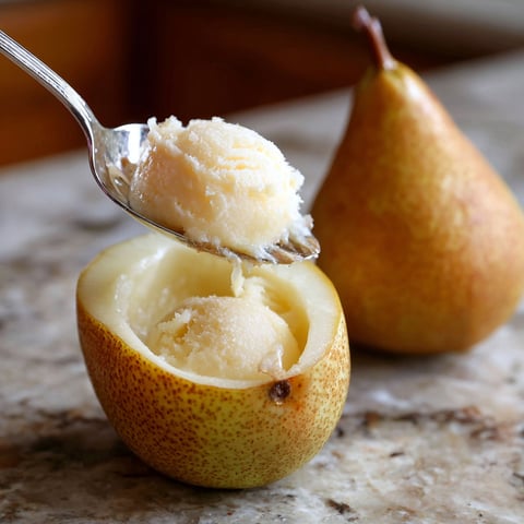 A fork is scooping out a piece of food from a pear.