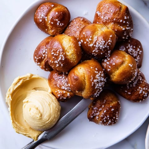 Golden brown Holiday Snack Pretzel Bites, glistening with egg wash and coarse salt topping.
