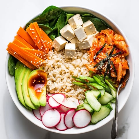 A colorful fermented vegetable bowl with tangy kimchi and fresh greens.  