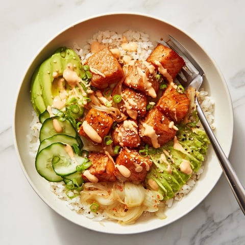 Crispy salmon rice bowl with vibrant toppings and creamy spicy mayo drizzled on top.  