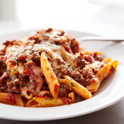 A creamy Cheesy Beef & Penne Bake with melting cheese and savory meat layers.  