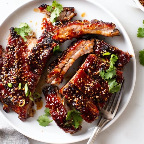 Succulent Sriracha honey glazed ribs topped with sesame seeds and fresh cilantro. 