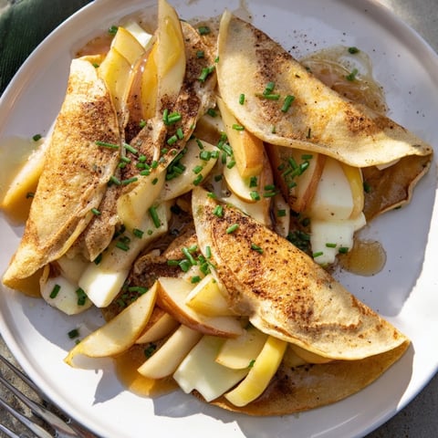 Golden crispy apple and Brie breakfast tacos drizzled with honey and chives.  