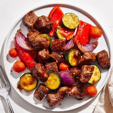 Succulent honey garlic steak bites served with vibrant roasted seasonal vegetables.