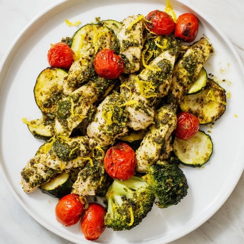 Golden-brown Quick Lemon Pesto Chicken Sheet Pan with roasted vegetables, a healthy Mediterranean delight.