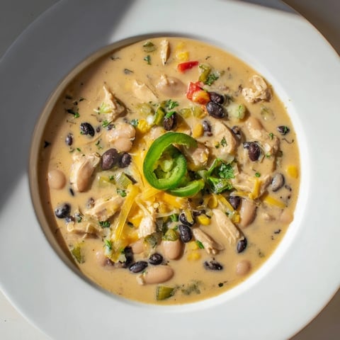 Steaming Slow Cooker White Chicken Chili with black beans, topped with fresh cilantro, ready to eat.