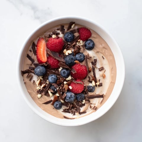 Silky smooth No-Bake Cottage Cheese Chocolate Mousse, swirled with melted chocolate and fresh berries.