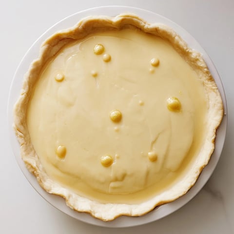 A golden-brown Water Pie glistens, ready to bake, showcasing its simple pantry-staple ingredients.