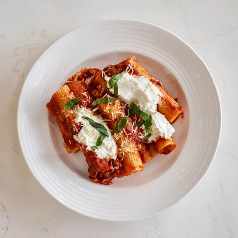 A bubbly, golden-brown One-Pan Baked Ziti, showcasing melted mozzarella cheese and simmering tomato sauce.