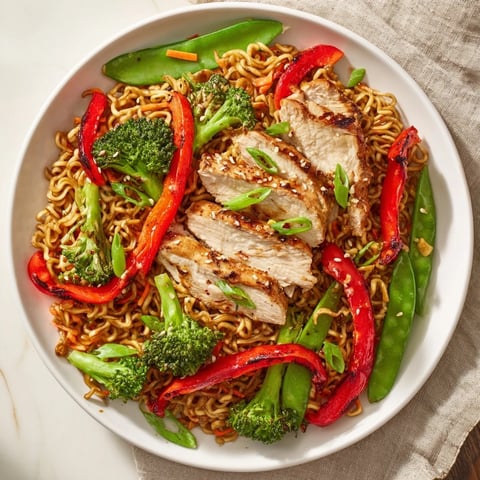 Golden sheet-pan crispy ramen with chicken, featuring vibrant roasted veggies and crispy noodles.