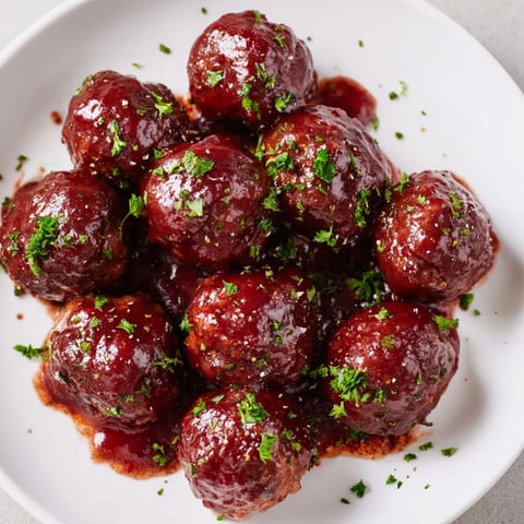 Steaming cherry BBQ meatballs simmered in a slow cooker, perfect for a flavorful appetizer or dinner.