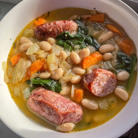 Steaming bowl of Simple Sausage and White Bean Soup, garnished, ready for a comforting, quick meal.