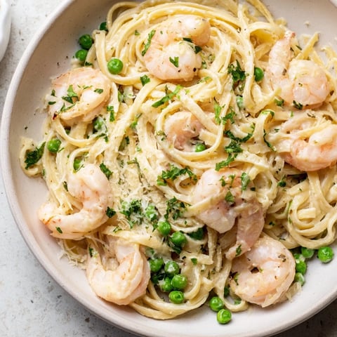 A steaming bowl of Instant Pot Shrimp Alfredo Pasta, creamy and garnished with parsley.