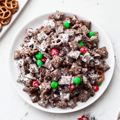 Snow-dusted Simplified Reindeer Chow mix with colorful candies and pretzels offers holiday flavors.