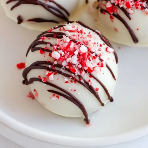 Shiny, white chocolate-covered Simplified Christmas Oreo Truffles, sprinkled with festive holiday colors.
