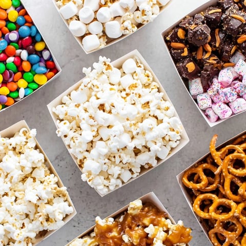 Fresh popcorn boxes brimming with colorful sweet and savory treats for a Movie Night display.