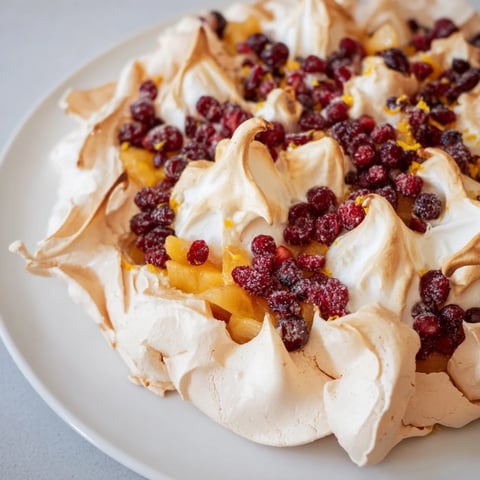 Golden-topped Cranberry and Pear Snowscape dessert with warmly cooked fruit, smelling of citrus and vanilla.