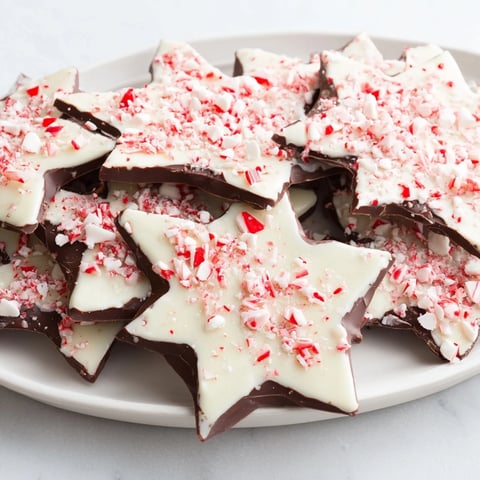 Close-up of vibrant Peppermint Bark Snowflakes: layers of chocolate topped with crushed peppermint candy.