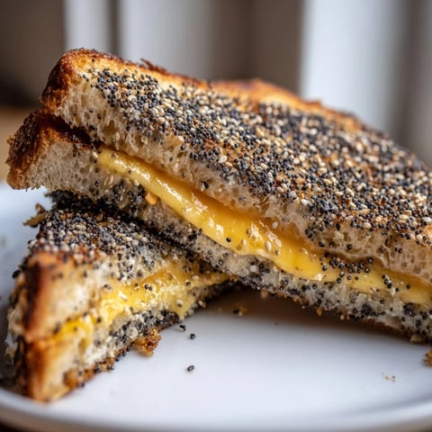 Golden-brown Everything Bagel Grilled Cheese, with melted cheddar oozing out between crispy toasted bread.