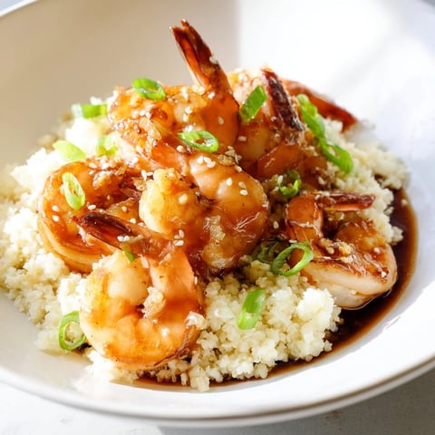Golden ginger garlic shrimp bowls with vibrant green onions and sesame seeds, ready to eat.