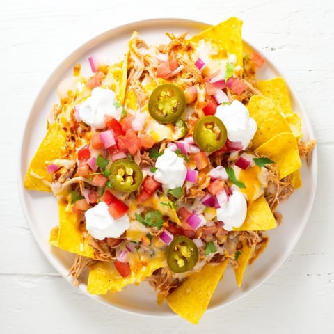 Loaded Nachos with Pulled Pork: A warm, cheesy delight with tender pulled pork and fresh toppings.